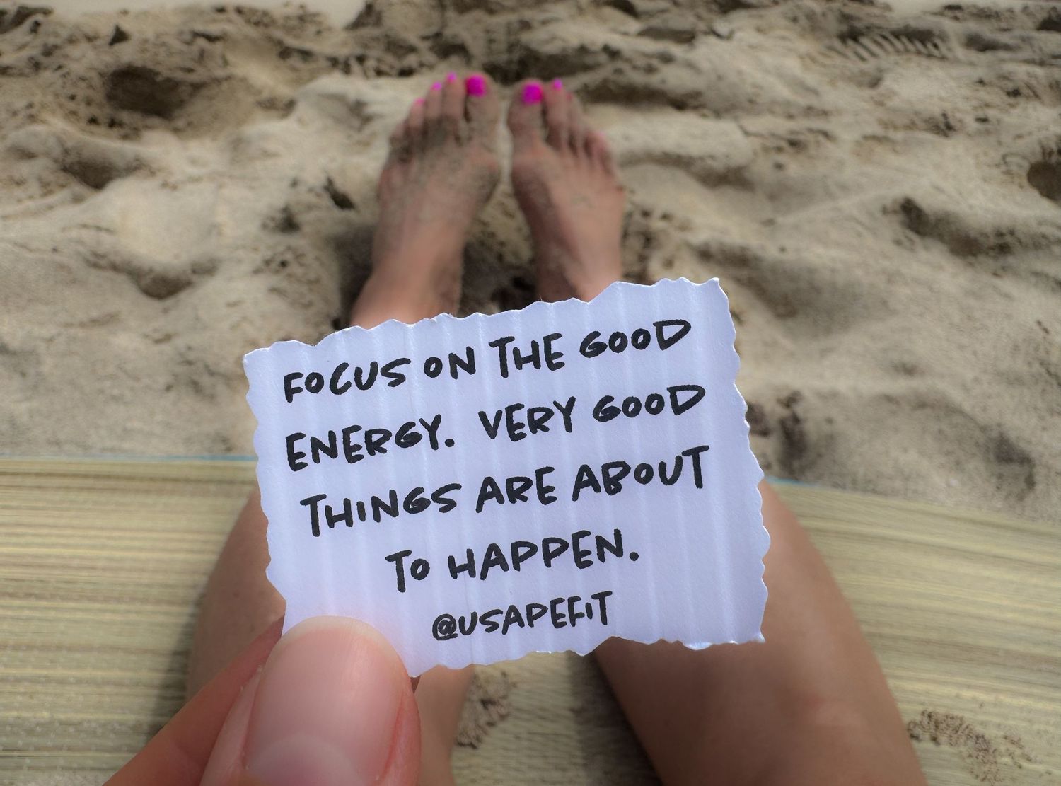 A series of five images showing feet in sand with handwritten motivational messages on paper notes at the beach.
