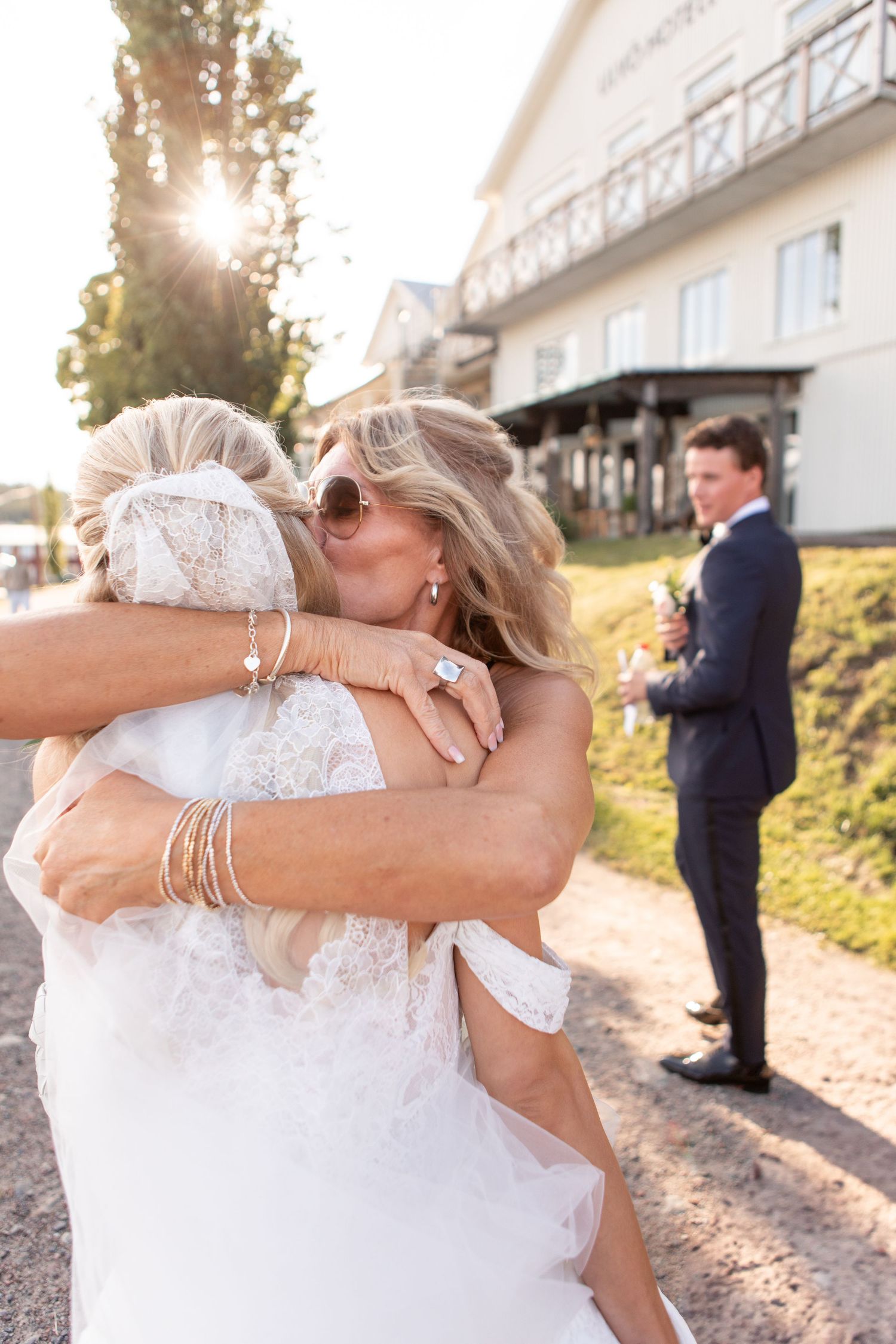 Emotional wedding moments captured during golden hour outside a white building.