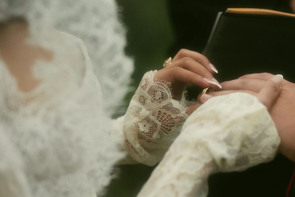 Close-up shot of hands delicately adjusting a lace wedding veil.