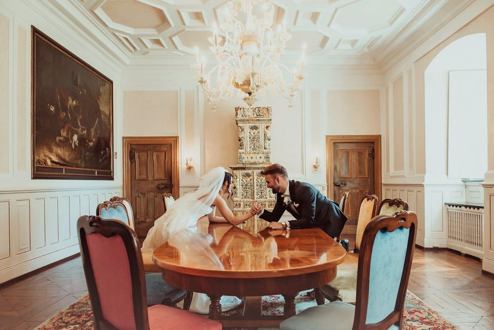 Elegant white walls and ornate crown molding adorn this bright formal parlor room with period furniture and crystal chandelier.