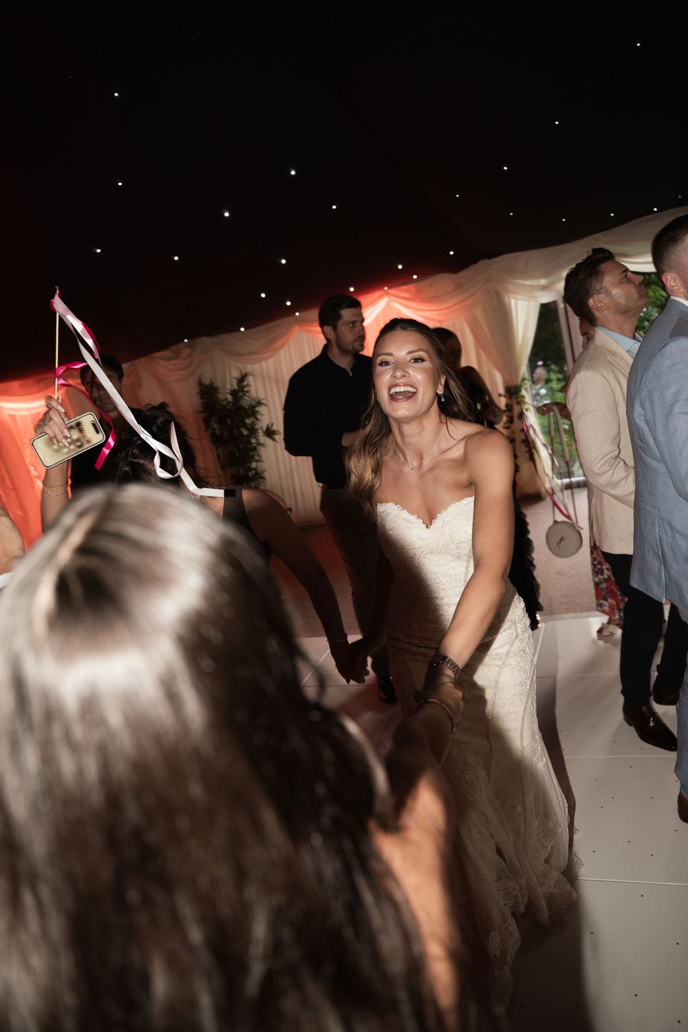People dancing and celebrating at a lively wedding reception party on the dance floor.