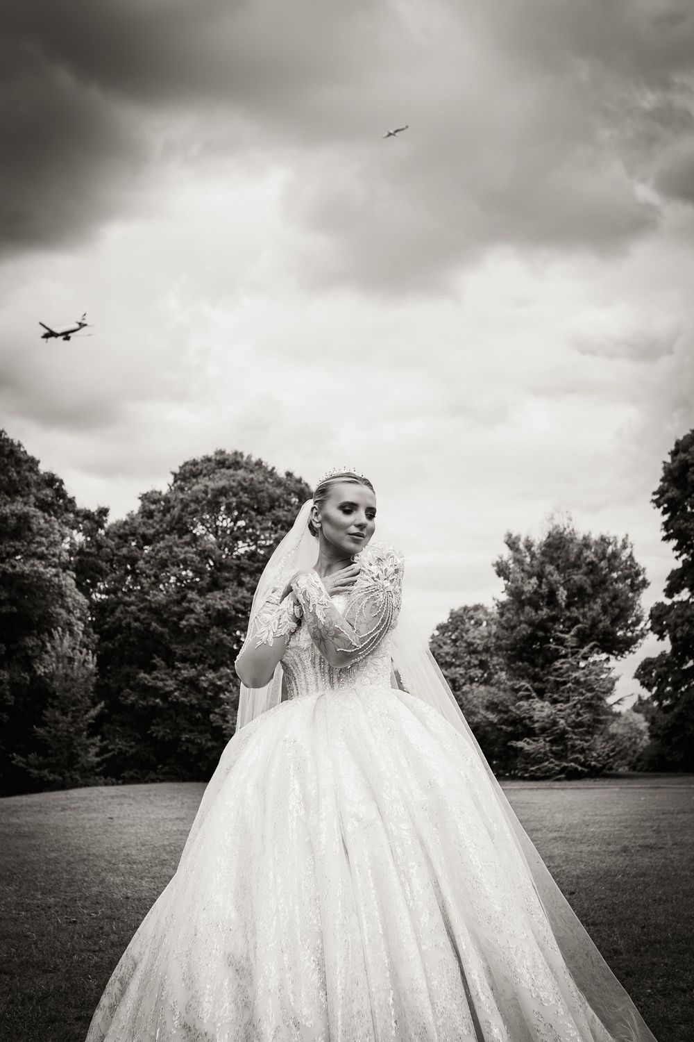A scenic black and white photo series of a wedding dress flowing in the wind against a dramatic cloudy sky.