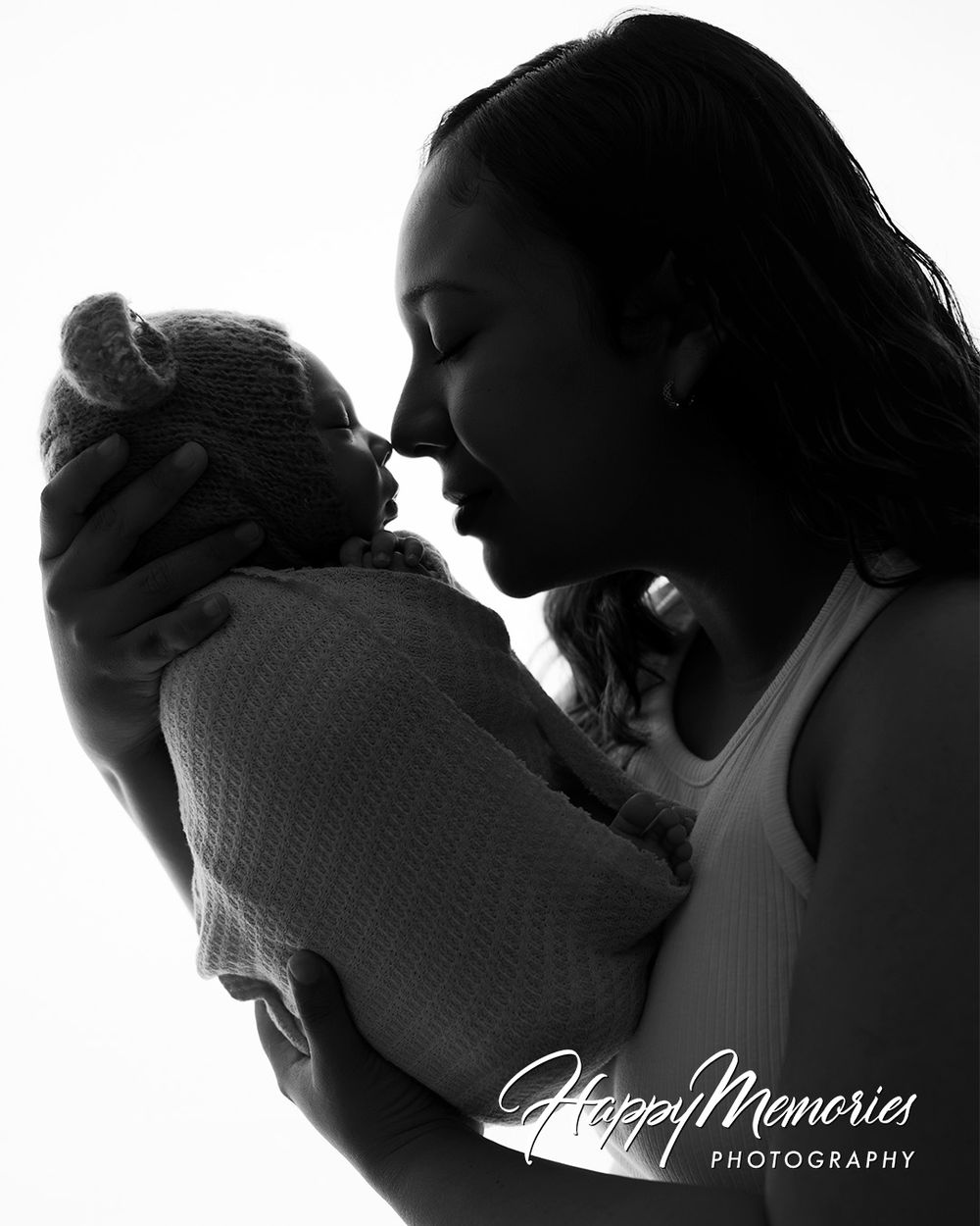 Black and white silhouette of tender newborn photography moment.
