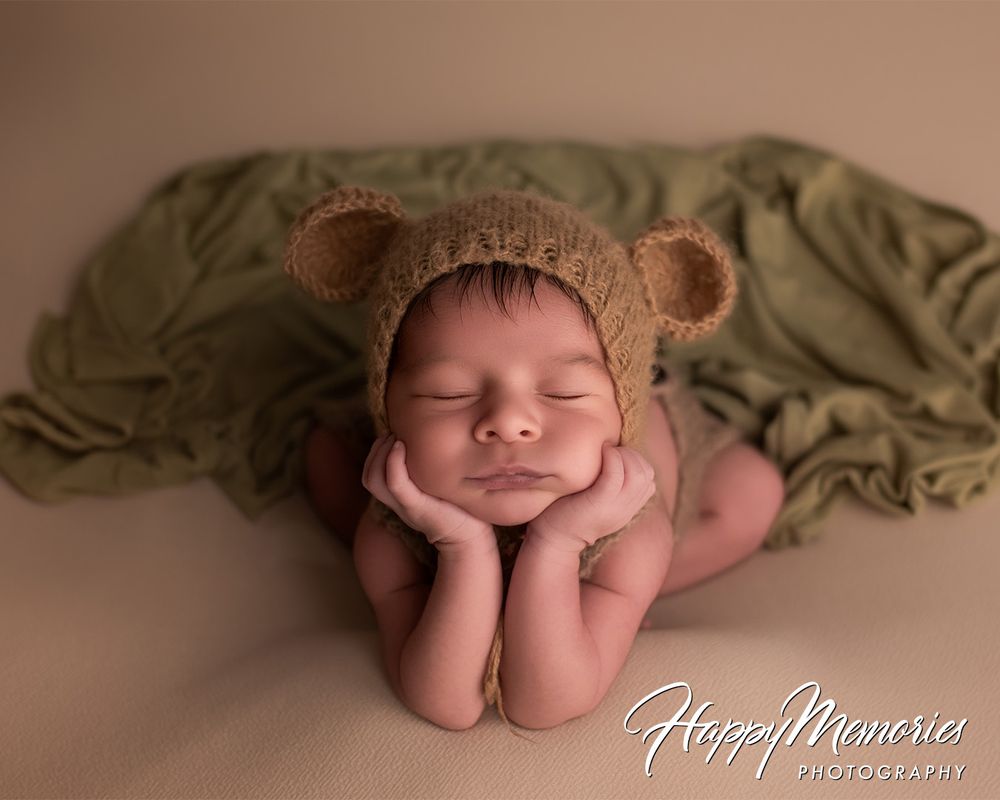 Peaceful newborn photography on soft brown backdrop in minimalist style.