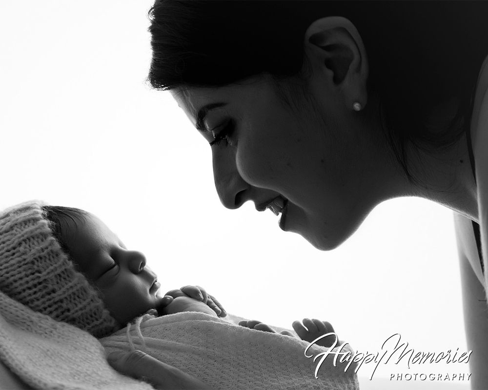 Black and white silhouette portrait of tender newborn photography session.