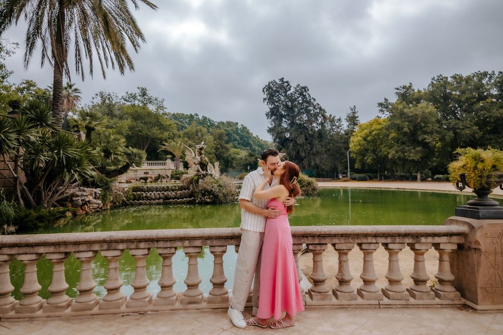 Romantic kiss with fountain backdrop in the park.