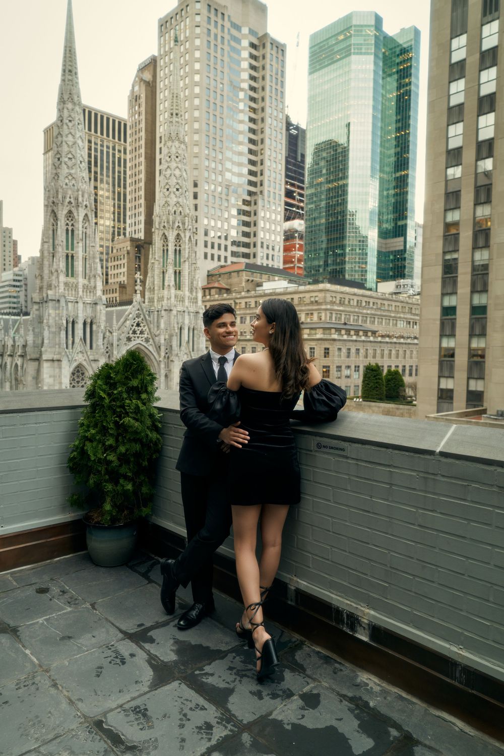 A couple embraces on a rooftop terrace with St. Patrick's Cathedral and Manhattan skyscrapers in the background by 3 West Club manhattan