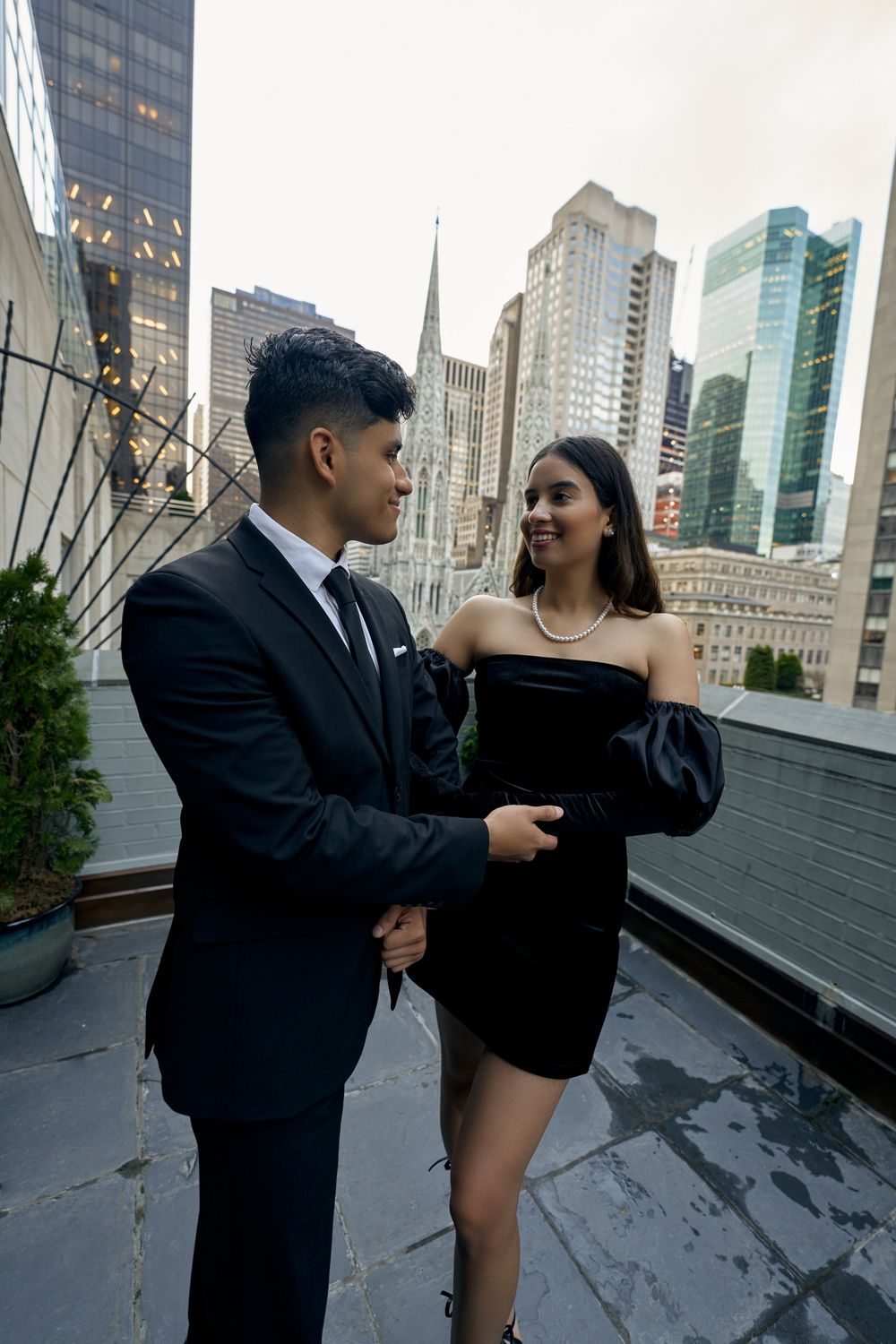A couple in formal attire share a romantic moment on an urban rooftop with city buildings in the background by 3 West Club manhattan