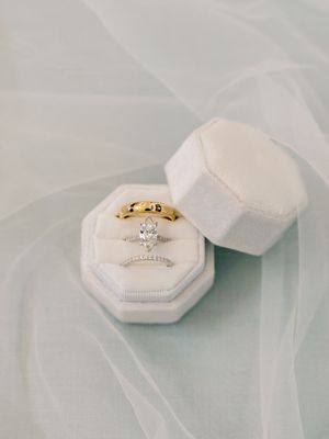 Diamond engagement ring in white octagonal box on tulle fabric.