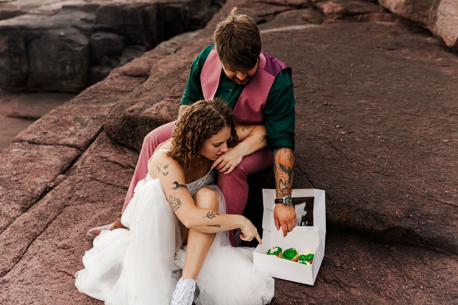 Bride and groom share intimate moments while seated on rustic stone steps during outdoor wedding photo session.