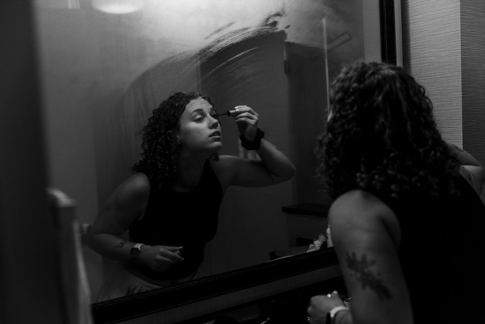 Two people in a darkened room with dramatic black and white lighting.