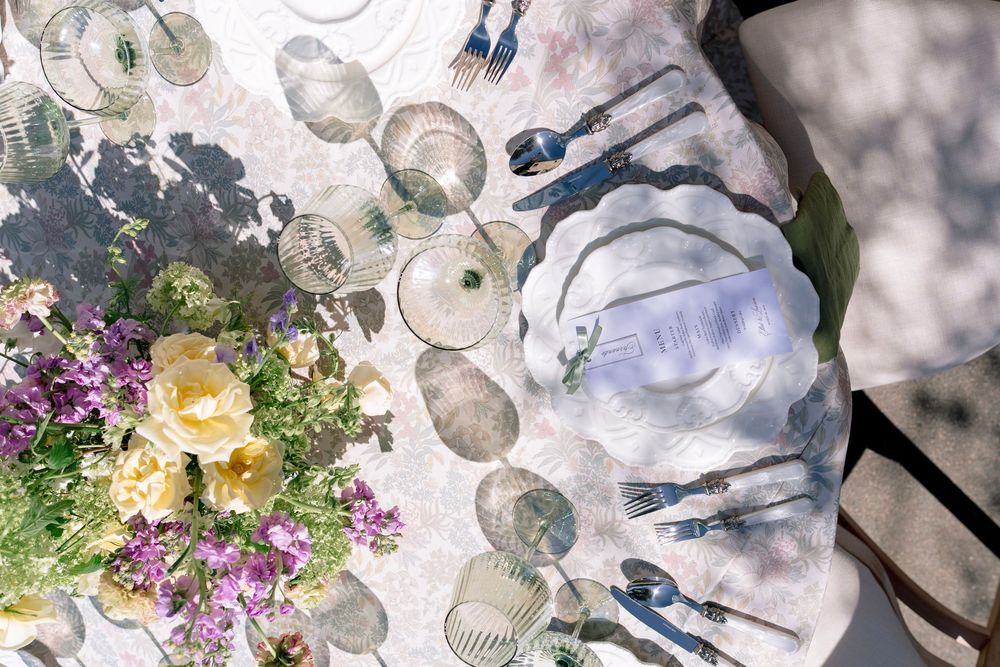 Overhead view of elegant wedding reception table with floral centerpiece and glassware.