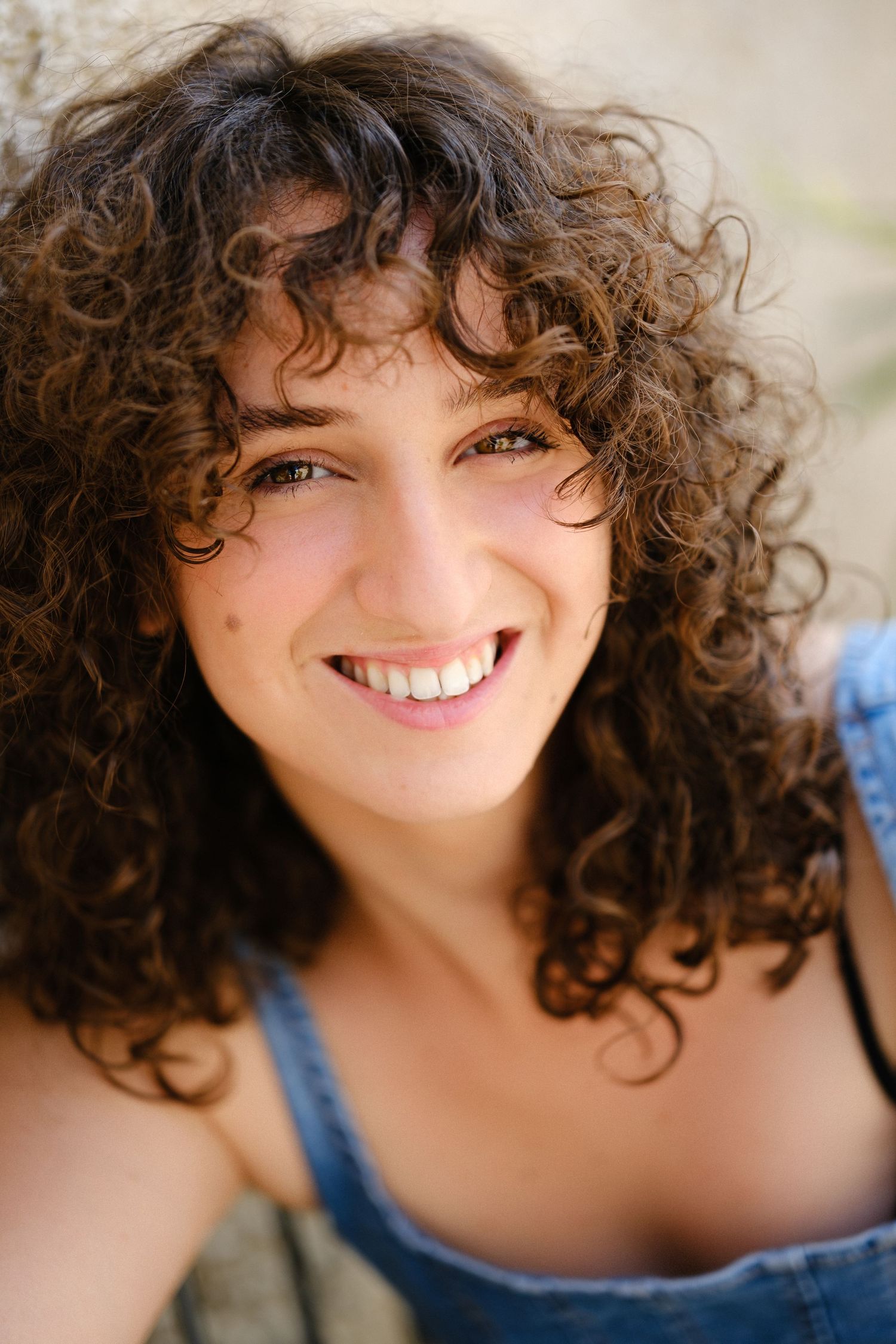 Close-up portrait series showing natural curly hair and denim outfit against a light background.