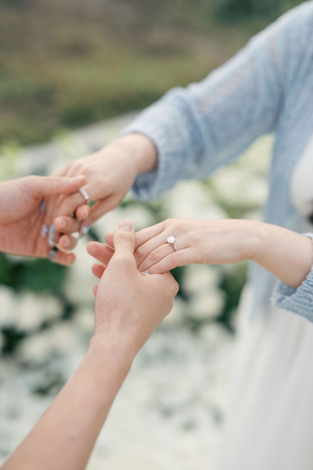 A close-up sequence showing two hands reaching out and joining together in a tender gesture against a soft blurred background.