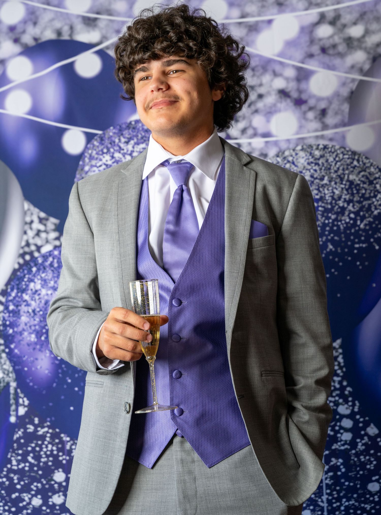 Five side-by-side formal portraits featuring a gray suit with purple vest against a sparkly blue and white backdrop.