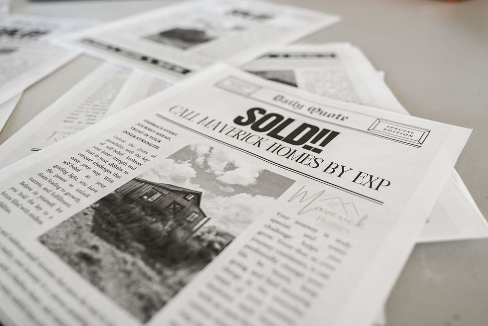 Closeup of black and white newspaper articles laid out on white surface.
