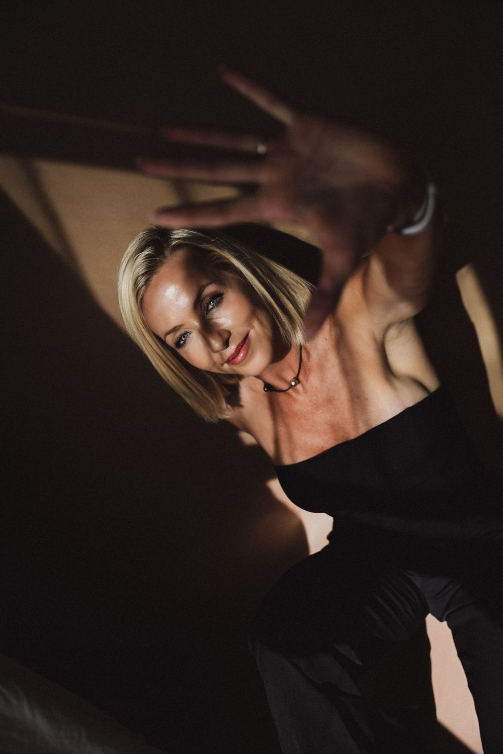 Dramatic low-key portrait in dark lighting with shadows and highlights.