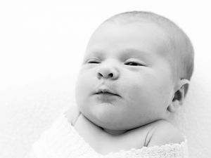 A creative black and white photography series showing multiple close-up views of a peaceful sleeping baby's expressions.