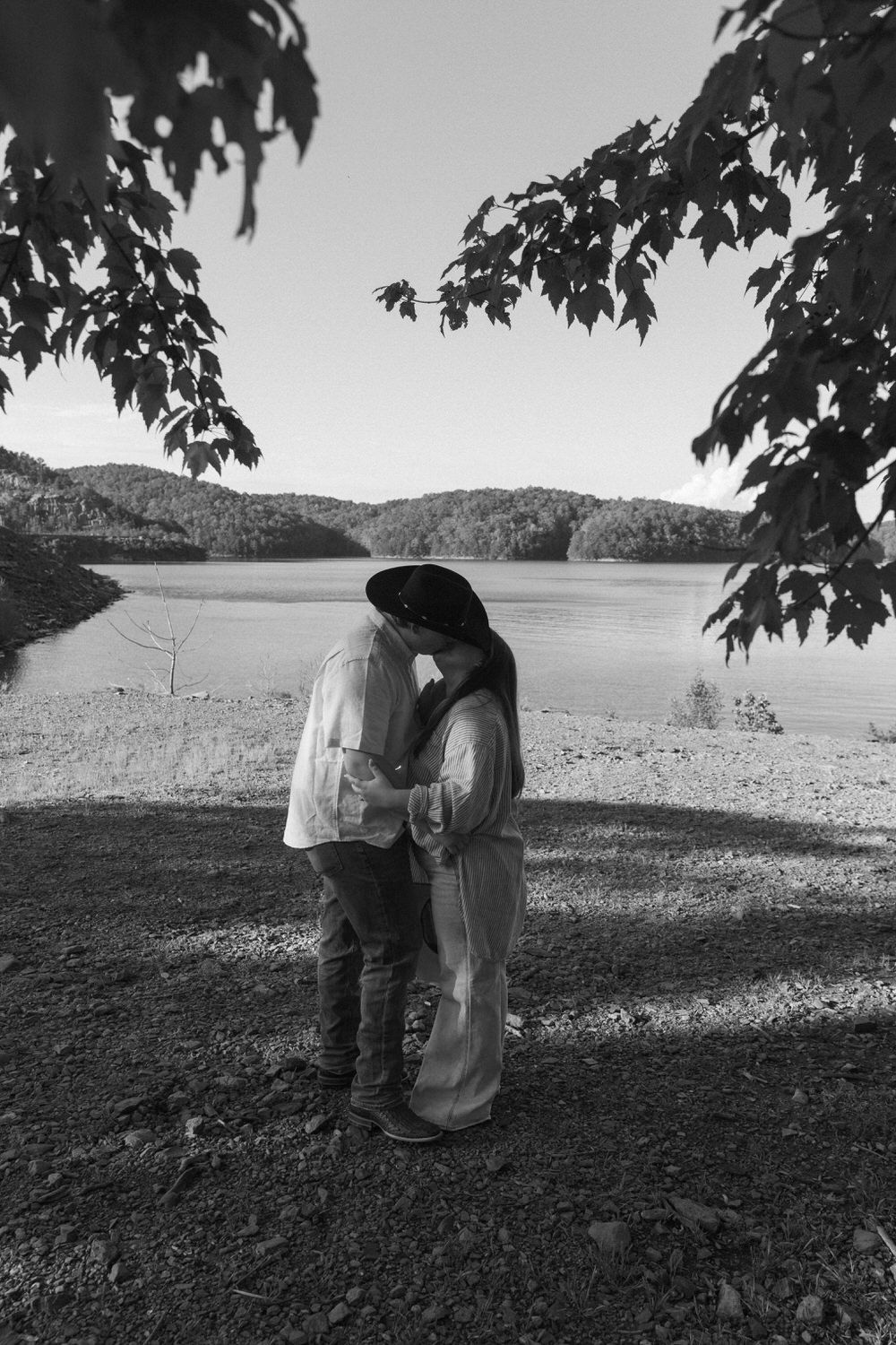 Couple standing nose-to-nose, smiling in cowboy boots during Georgia engagement photos
