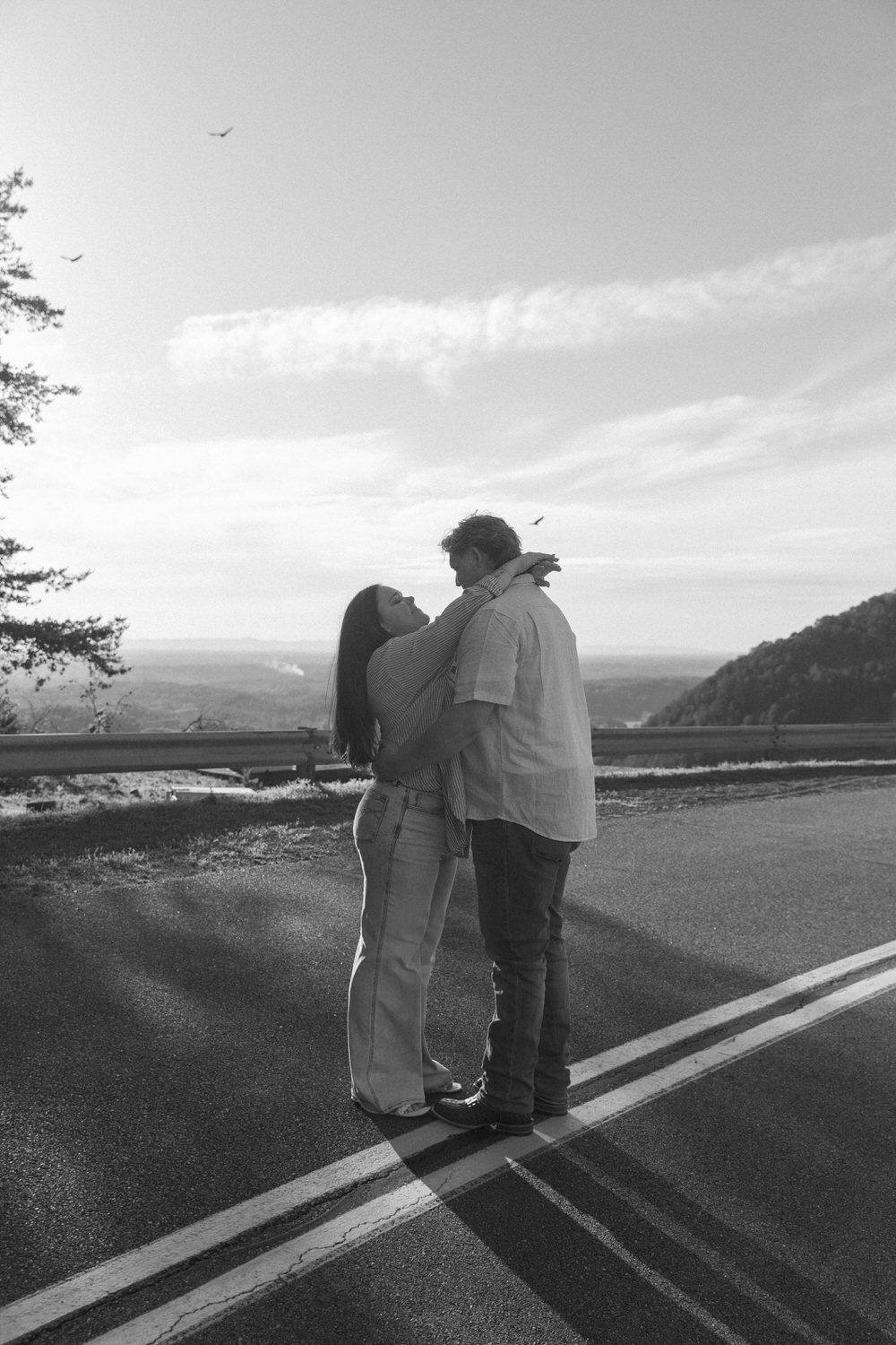 A couple embracing in the middle of the road during their North Georgia engagement session.