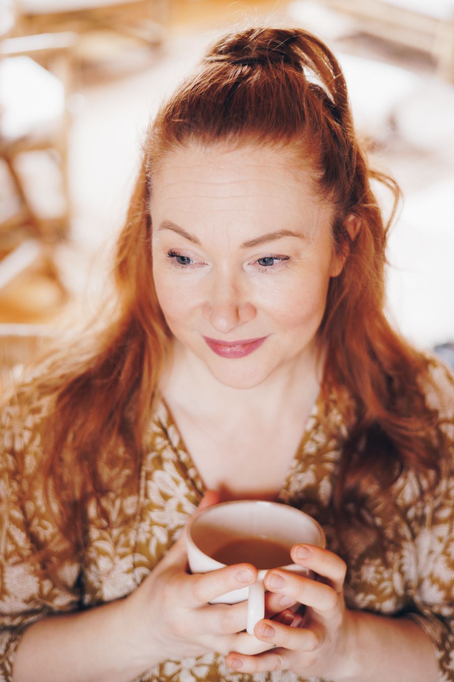 A series of photos showing a person with red hair laughing while looking down at something in their hands.