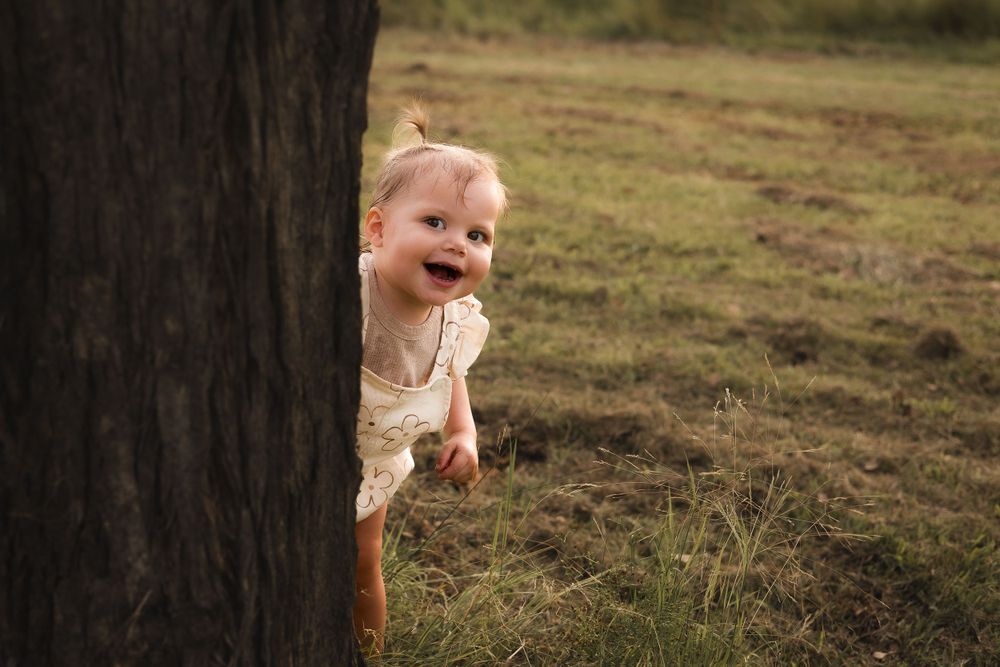 toddler playing during a photoshoot at Kingaroy Dam, bathed in warm golden light during sunset. Peek-a-boo In the south Burnett