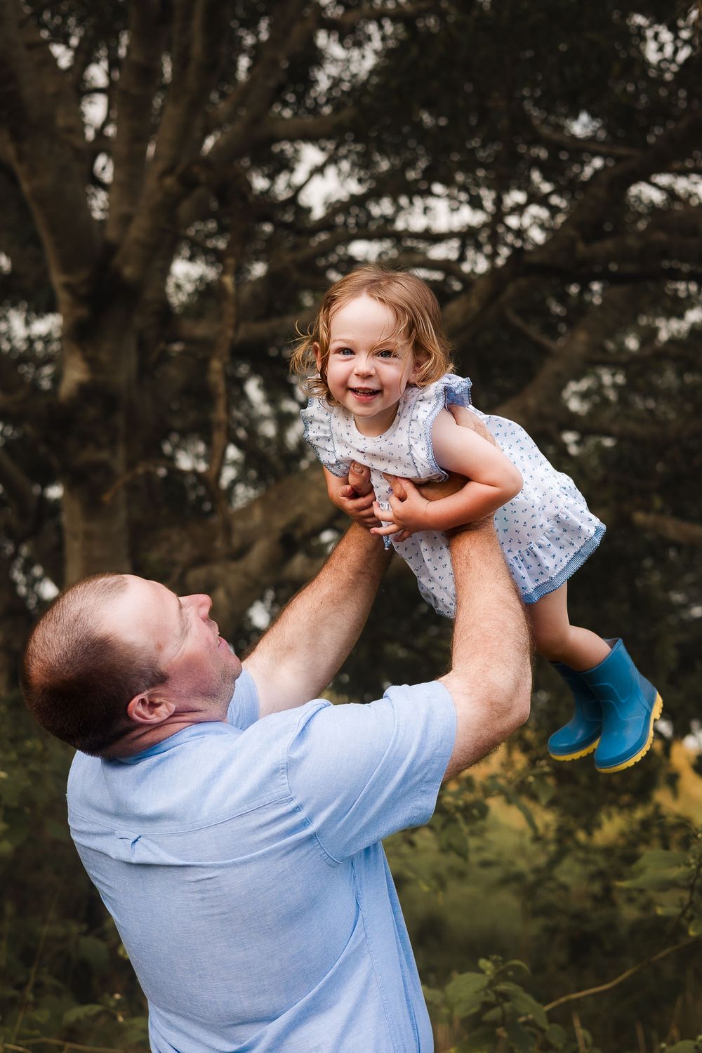 candid photo of toddler and dad playing on a farm in Gympie after a storm capturing a beautiful and sweet moment in nature during photoshoot