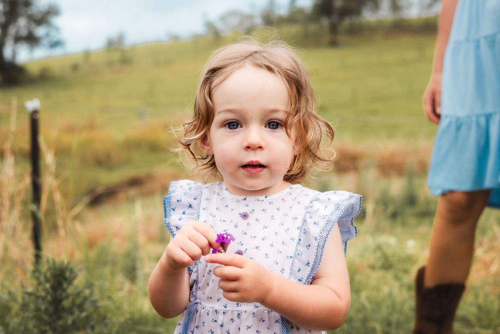 candid photo of toddler on a farm in Gympie after a storm, capturing a beautiful and sweet moment in nature during photoshoot