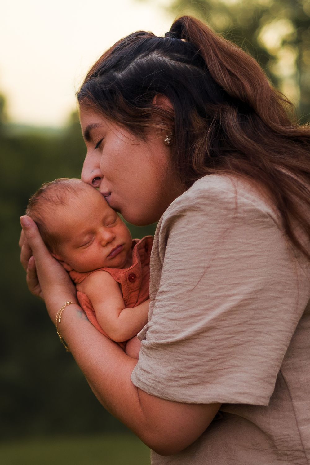 Newborn photoshoot in the forest at sunset in the Sunshine Coast with mum kissing baby