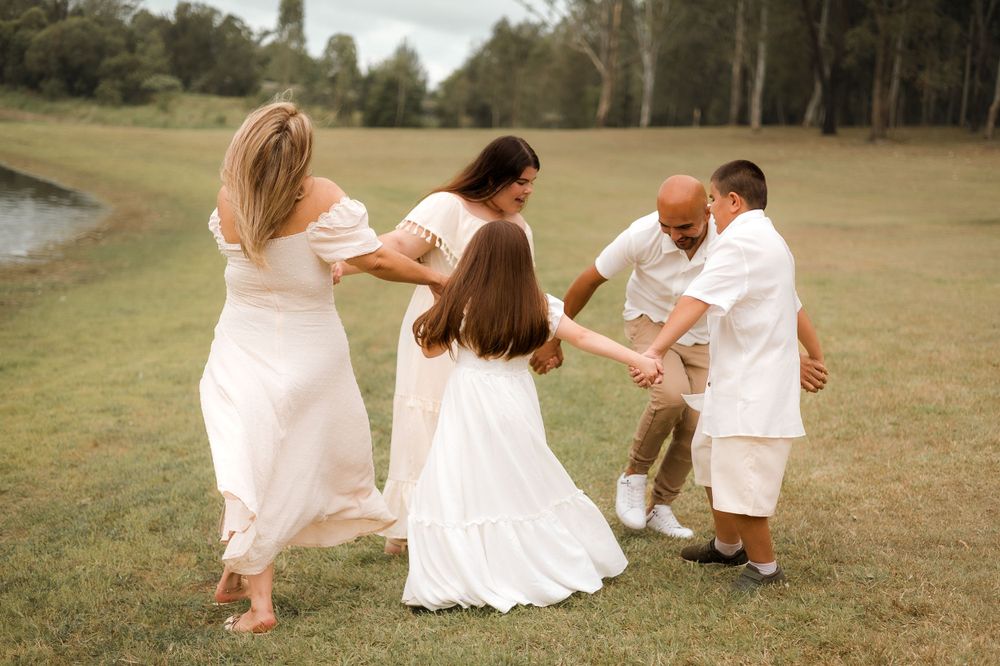 Family sharing a fun and laughter-filled moment during a candid photoshoot at Lake Samsonvale, Joyner, surrounded by nature