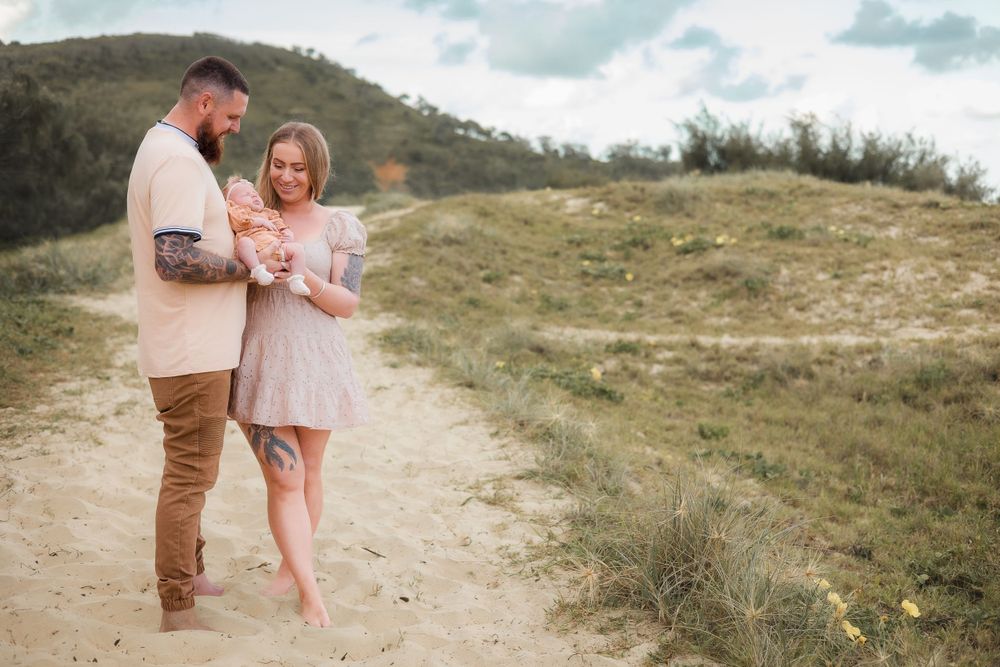 Sunshine Beach, Sunshine Coast, newborn photography session featuring parents embracing their baby in a natural, lifestyle setting