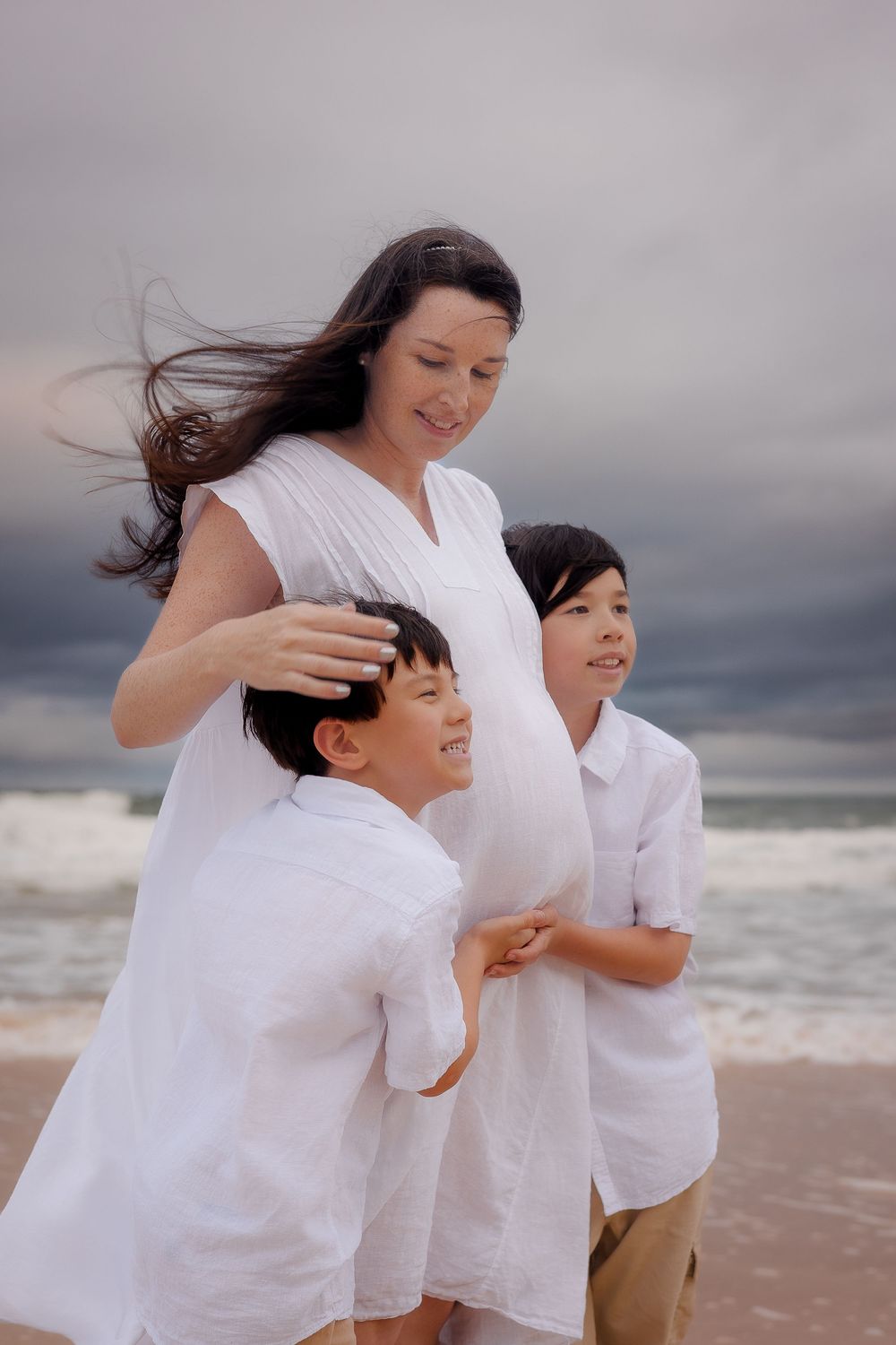 Emotive motherhood portrait on the Sunshine Coast beach, capturing the strength and beauty of pregnancy in a moody landscape.