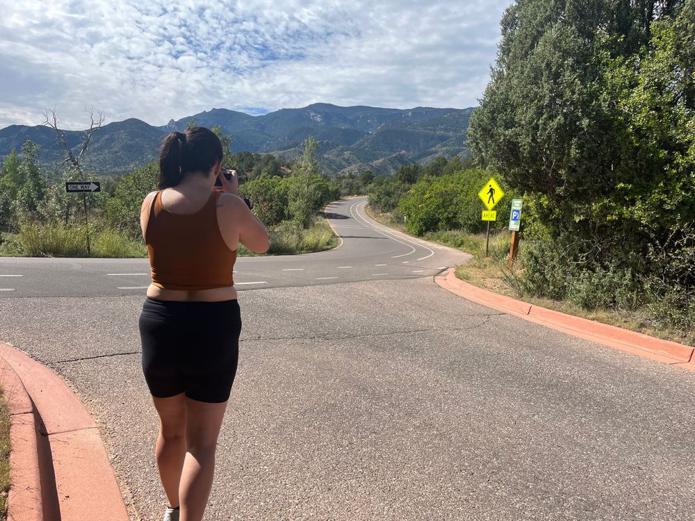 woman taking film photo at garden of the dogs in colorado springs