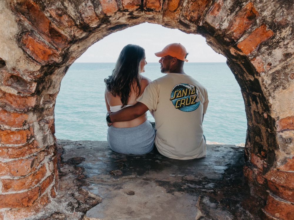 man and woman at fort charlotte in jamaica posing by the ocean