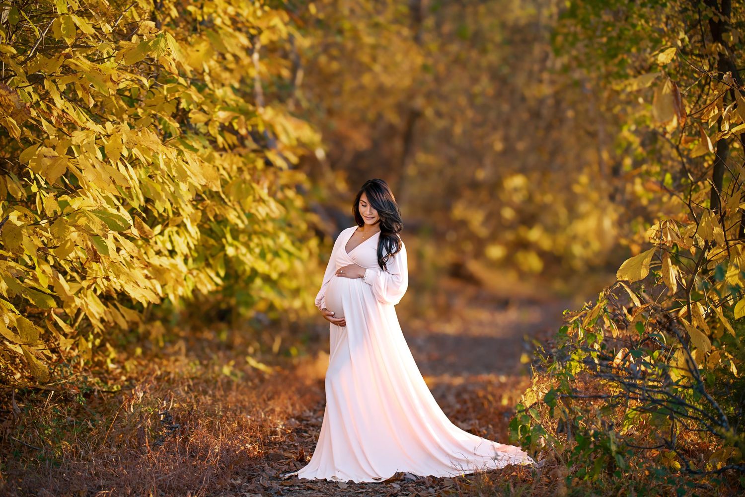 White flowy dress portrait in a golden autumn forest setting.