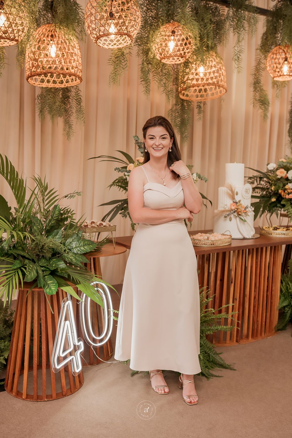 Elegant party setting with woven pendant lights, greenery, and wooden decor elements featuring neon number 40 display.