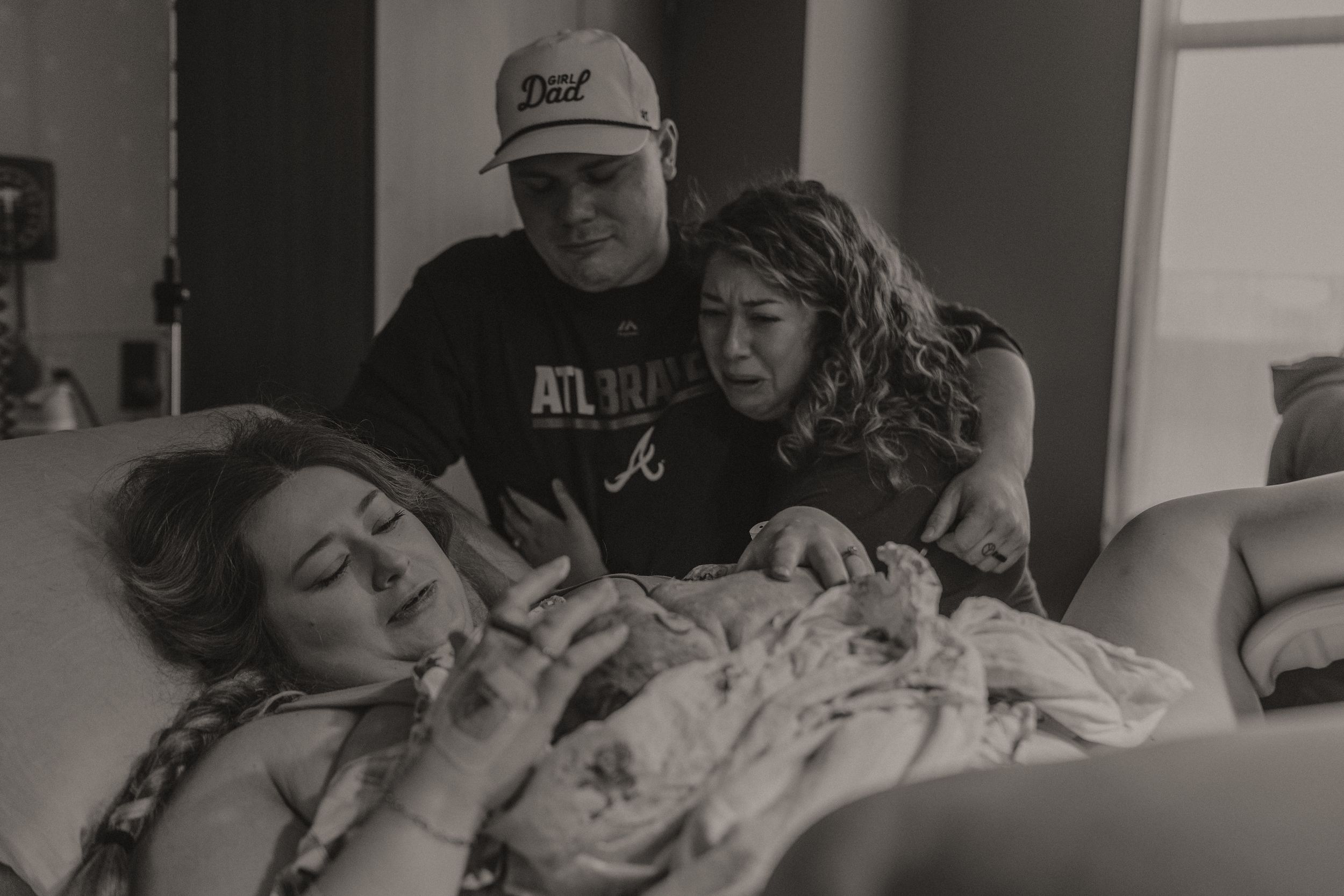 Black and white photo showing supportive moment in hospital room.