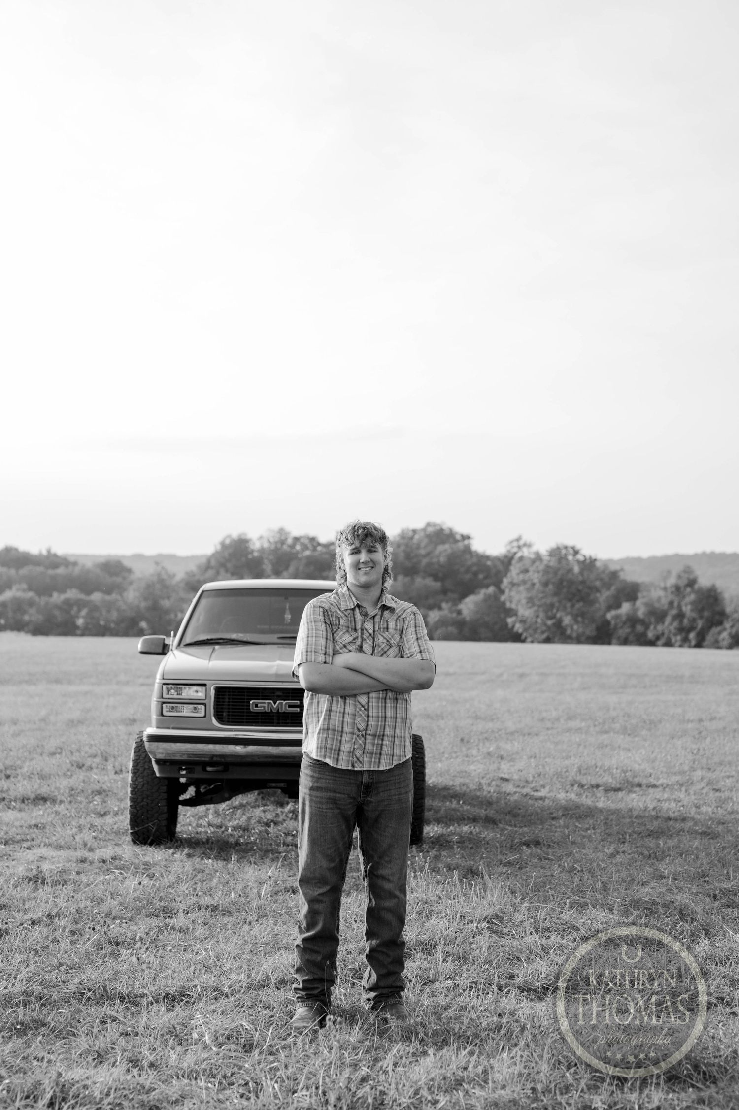 A black and white portrait with a classic GMC truck in a rural field setting.