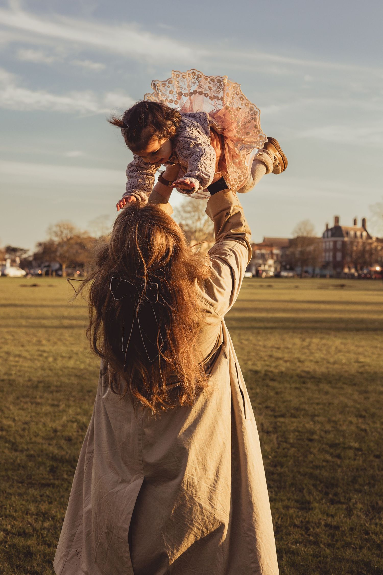 mum throwing toddler in the air outdoors