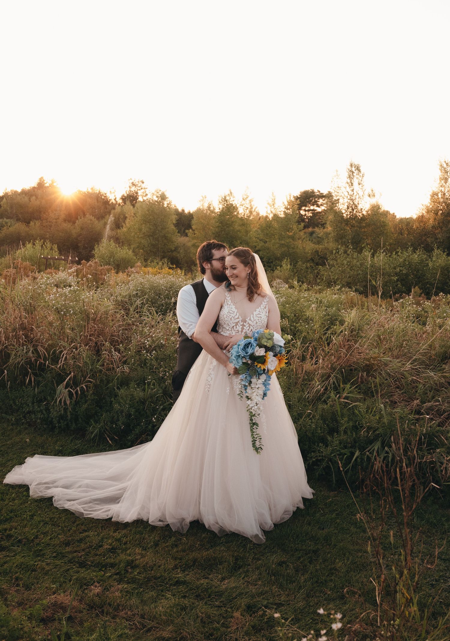 A romantic seaside wedding photoshoot with crashing waves and rocky coastline in the background.
