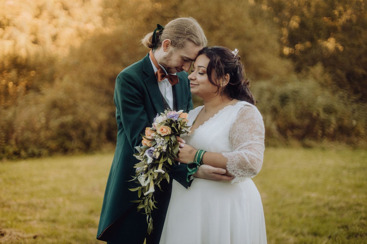 Photos de mariage romantiques en automne au Domaine de Fohet, La Bourboule – couple en tenue élégante devant le feuillage doré.