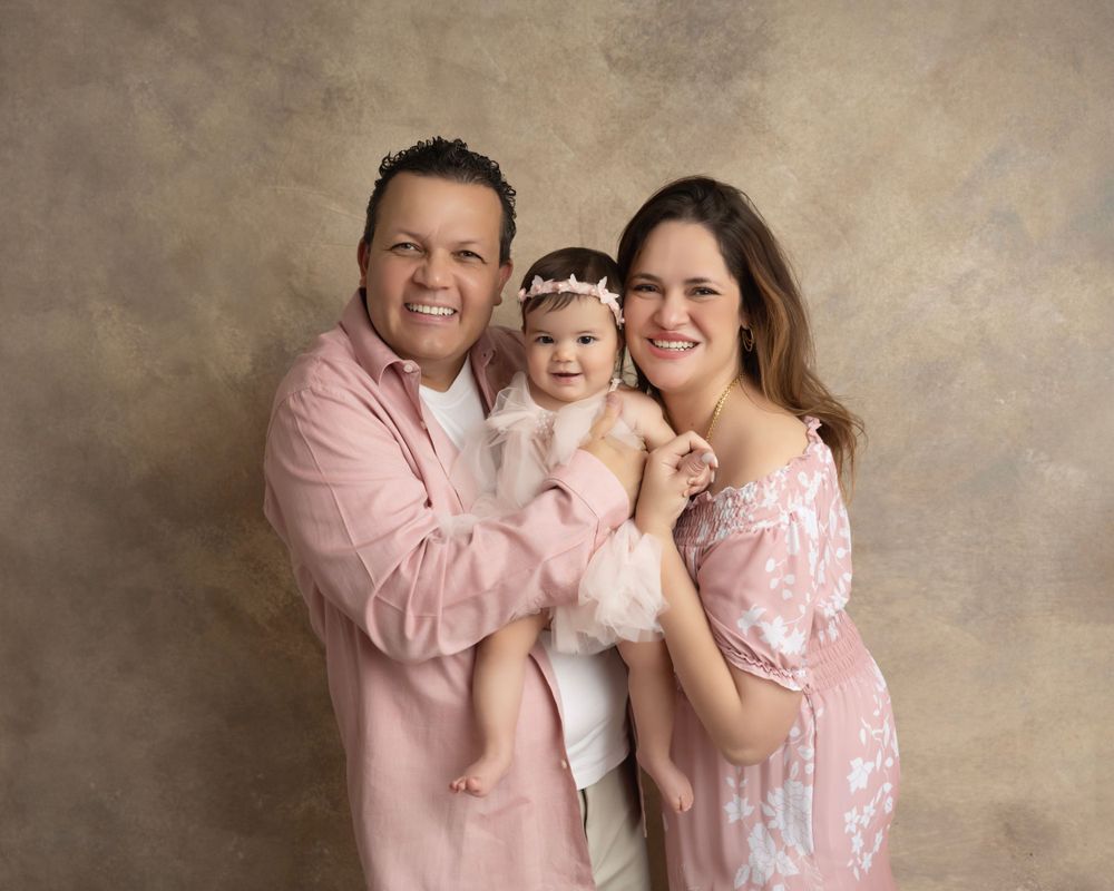 Candid family portrait series capturing genuine laughter and love in matching pink attire.