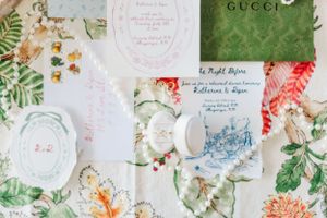 Vintage-style floral pattern with Gucci branding and delicate botanical illustrations in soft pastel colors.