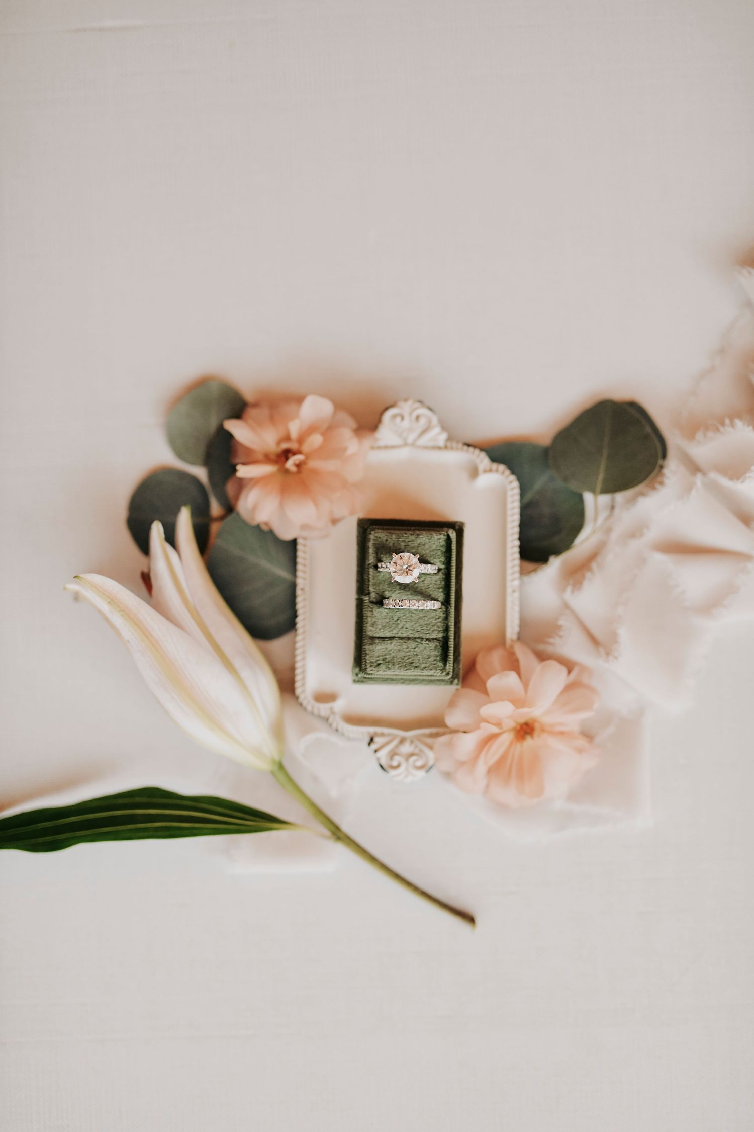 organic wedding flat lay with greenery, vow books, and delicate textures