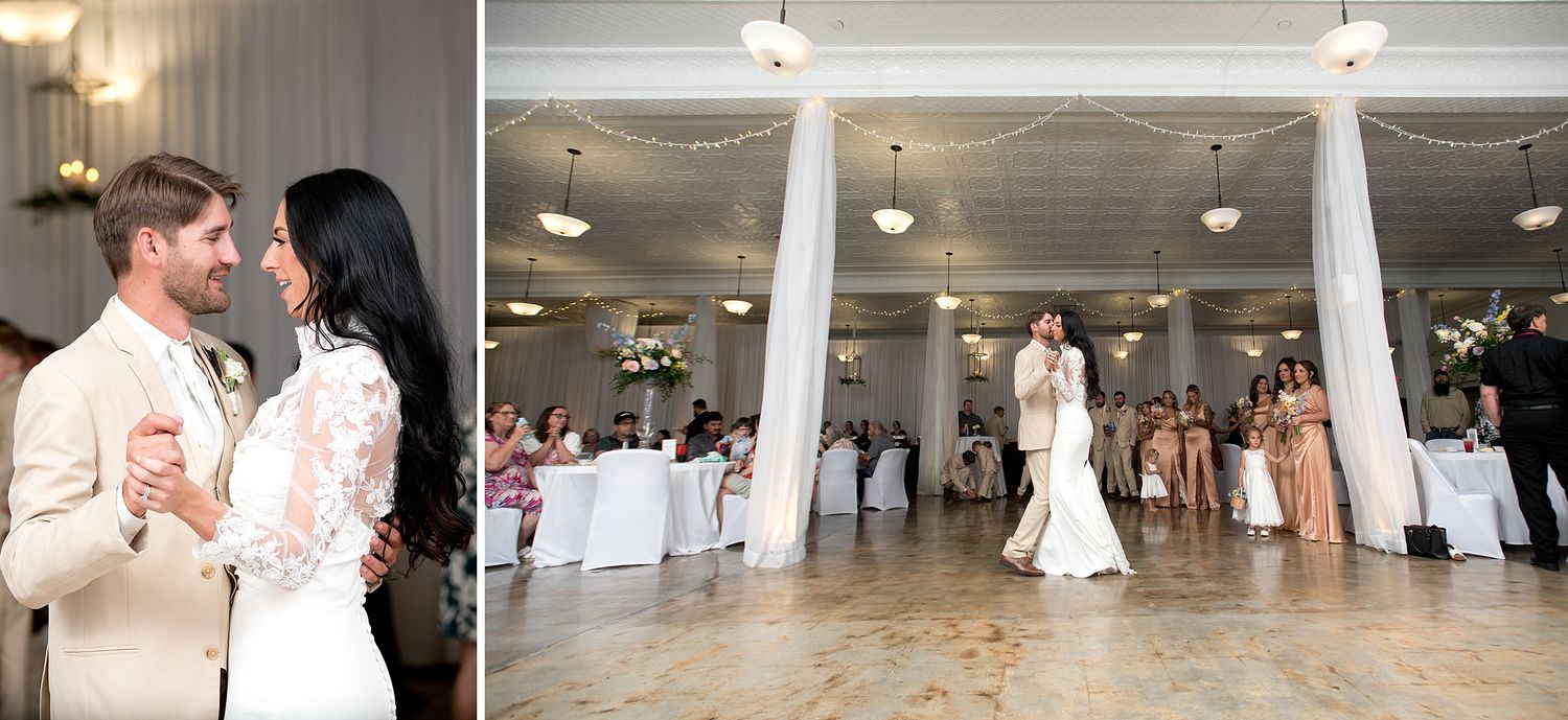 Bride and groom share their first dance in an elegant white ballroom with columns and wedding guests watching.