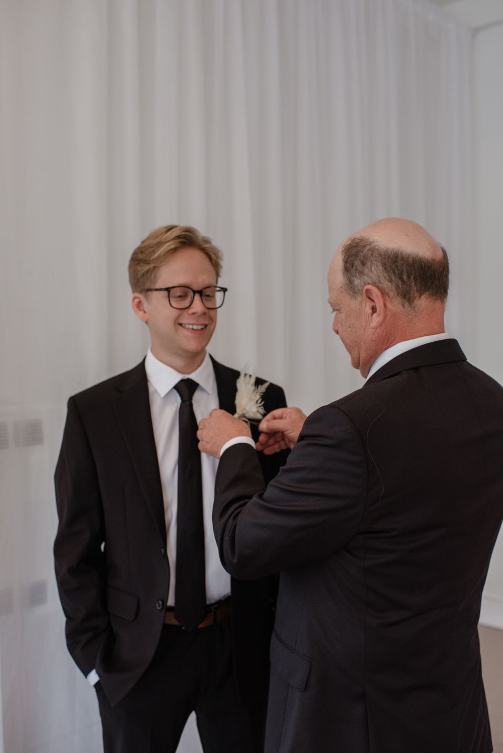 Black and white photo series showing playful poses in formal attire against white backdrop.