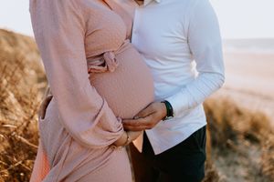 Zwangerschapsshoot vrouw met man met golden hour op het strand in Terneuzen, Zeeland, Oost-Vlaanderen