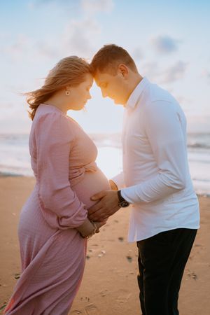Zwangerschapsshoot vrouw met man met golden hour op het strand in Terneuzen, Zeeland, Oost-Vlaanderen