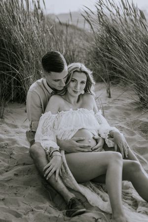 Zwangerschapsshoot vrouw met man op het strand met golden hour in Terneuzen, Zeeland, Oost-Vlaanderen