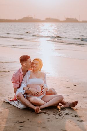 Zwangerschapsshoot vrouw met man op het strand met golden hour in Terneuzen, Zeeland, Oost-Vlaanderen